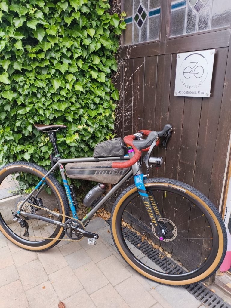 Gravel bicycle from Niner leaning against Barn doors and Ivy hedge